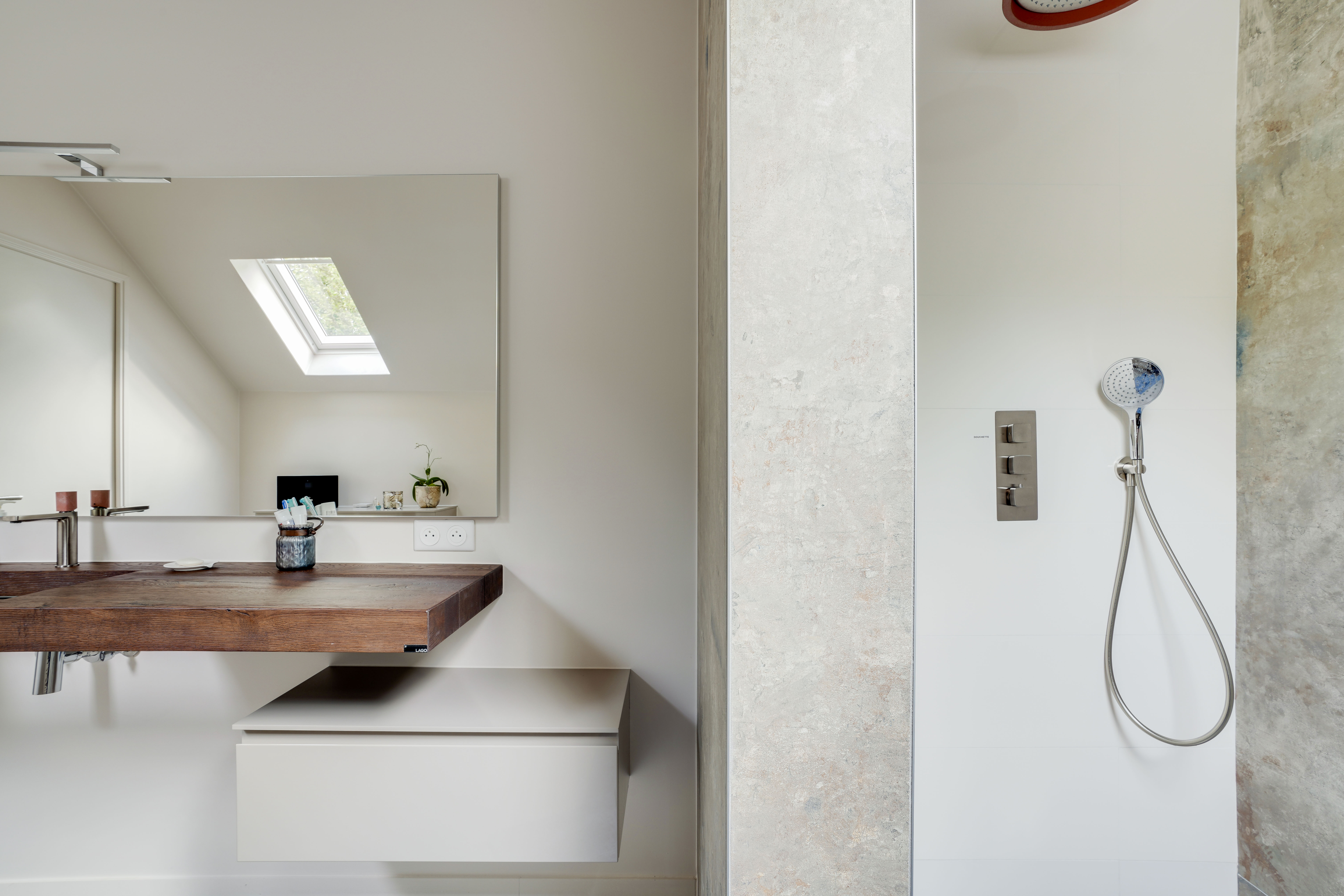 Transformation salle de bains 77 avec lavabo flottant bois, miroir mural, douche italienne et puits lumière naturelle, rénovation 3 pièces.