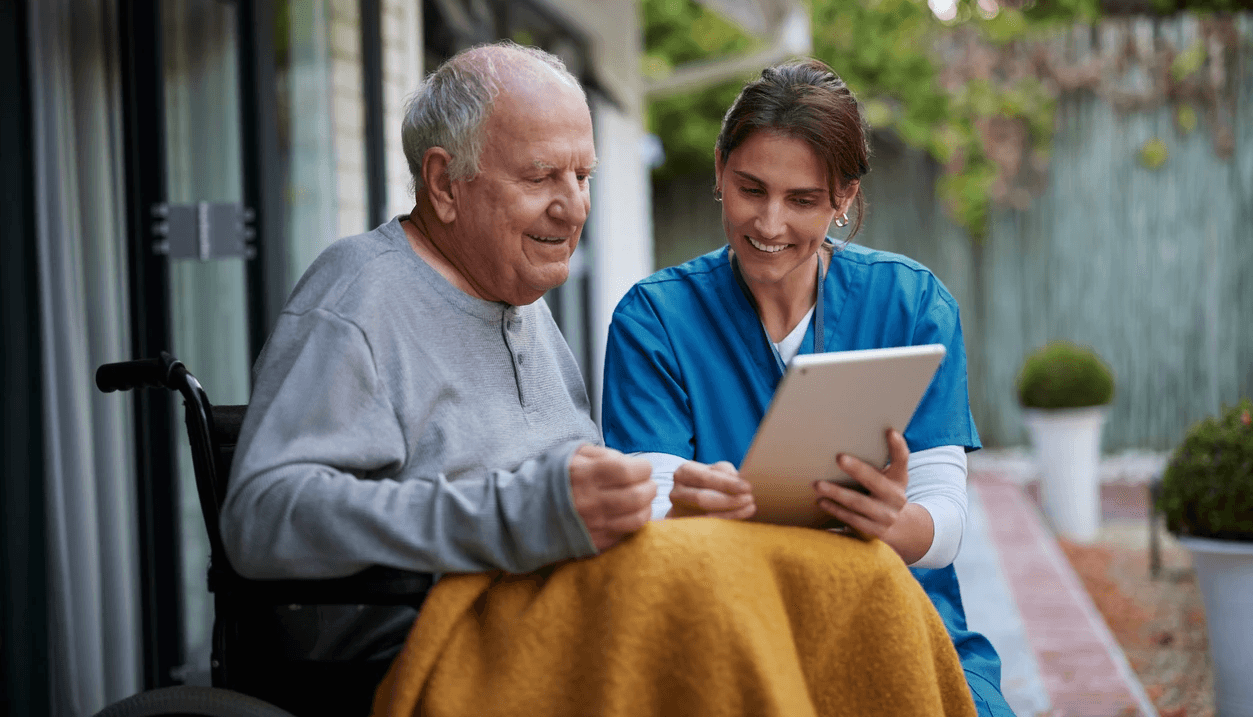 Senior with home health nurse outside of his home
