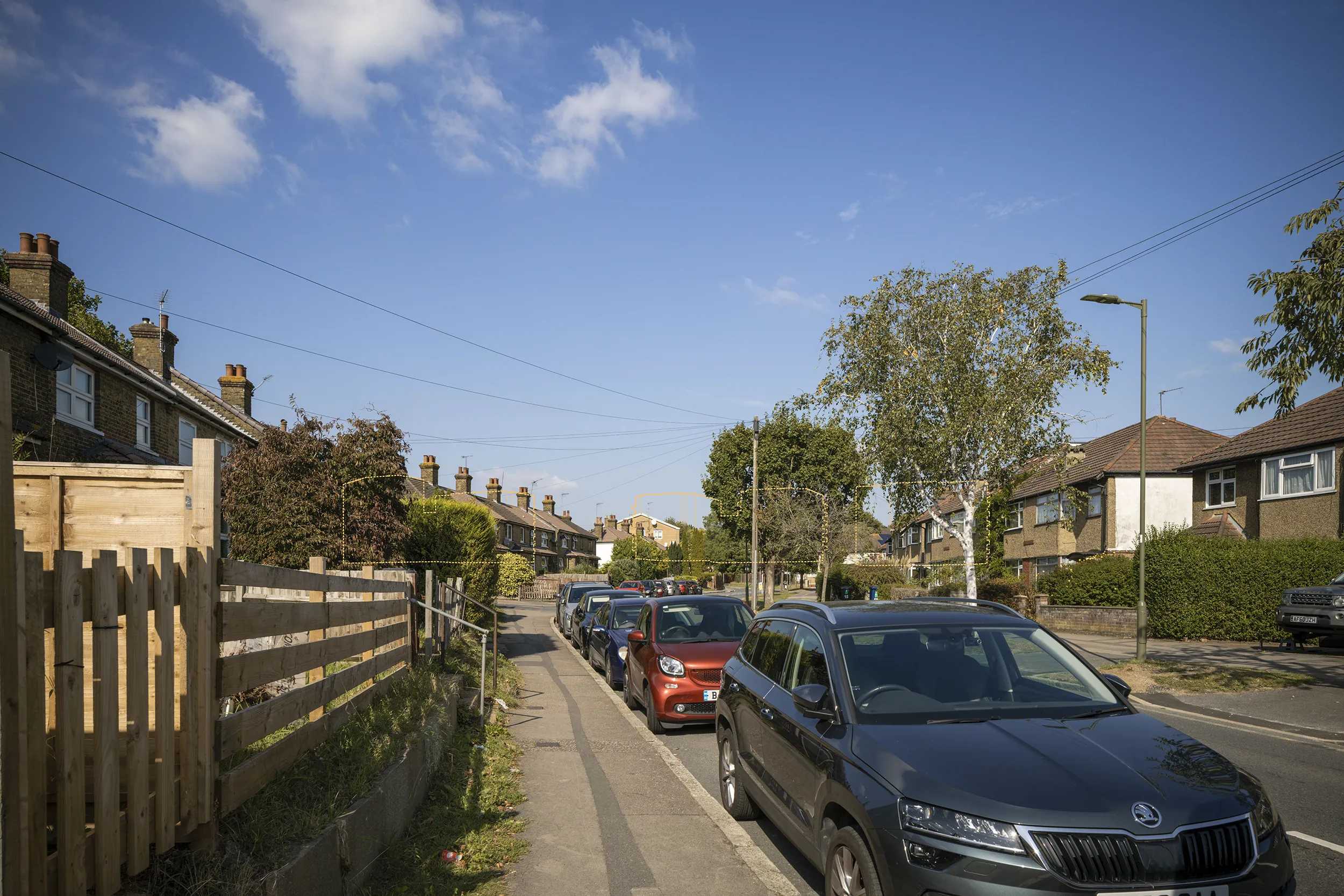 Type 4 AVR Level 1 wireline verified view due north along Barnet Lane near the Ark Pioneer Academy, with the upper levels of Buildings C, D and E filtered through the street trees.