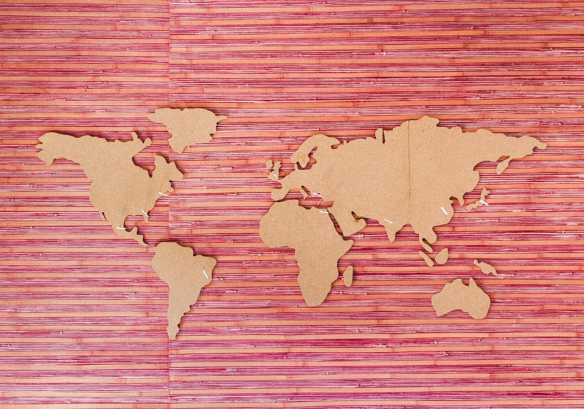 Map of the world using wooden cutouts on a cloth background