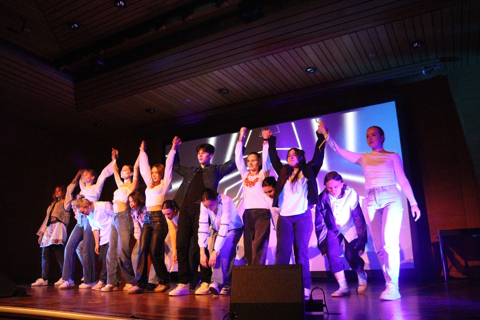 Young people on stage performing together.