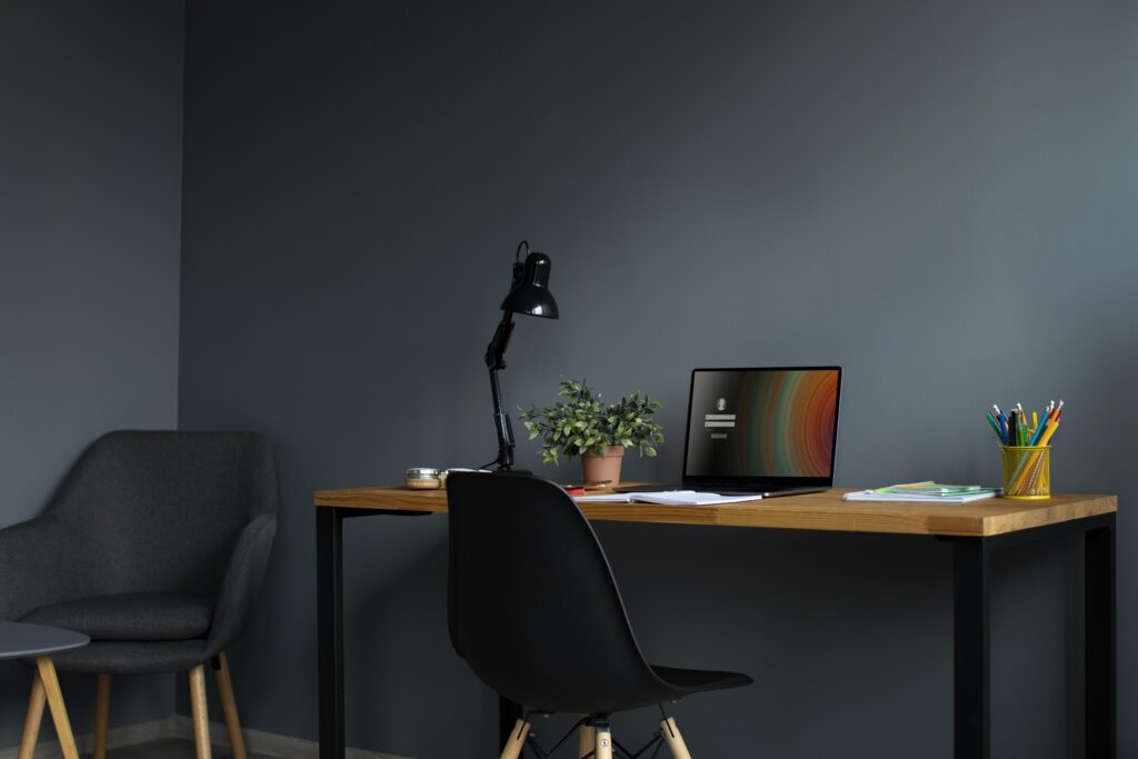 A home office layout featuring a laptop, desk lamp, and pen holder, creating a simple and organised workspace.