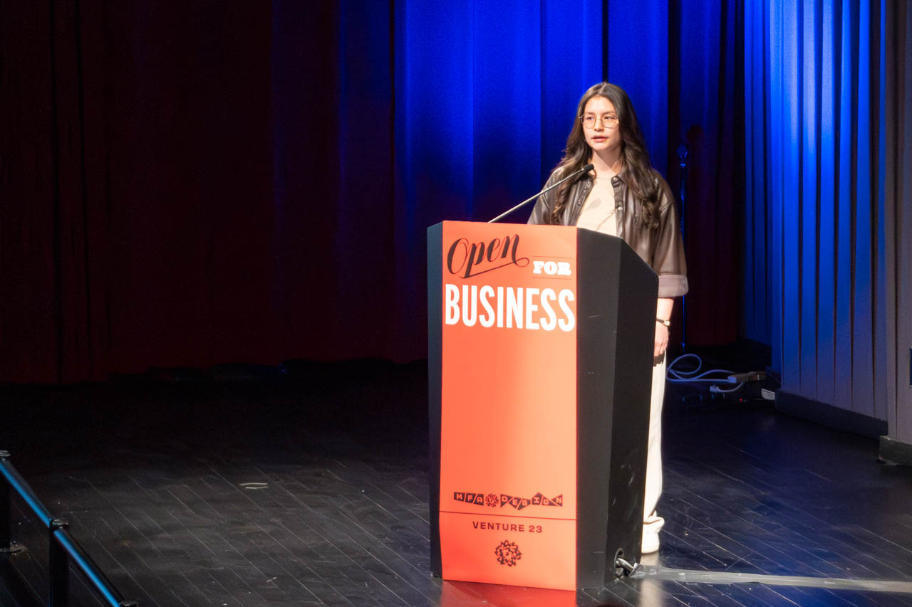 woman standing at a podium delivering a presentation