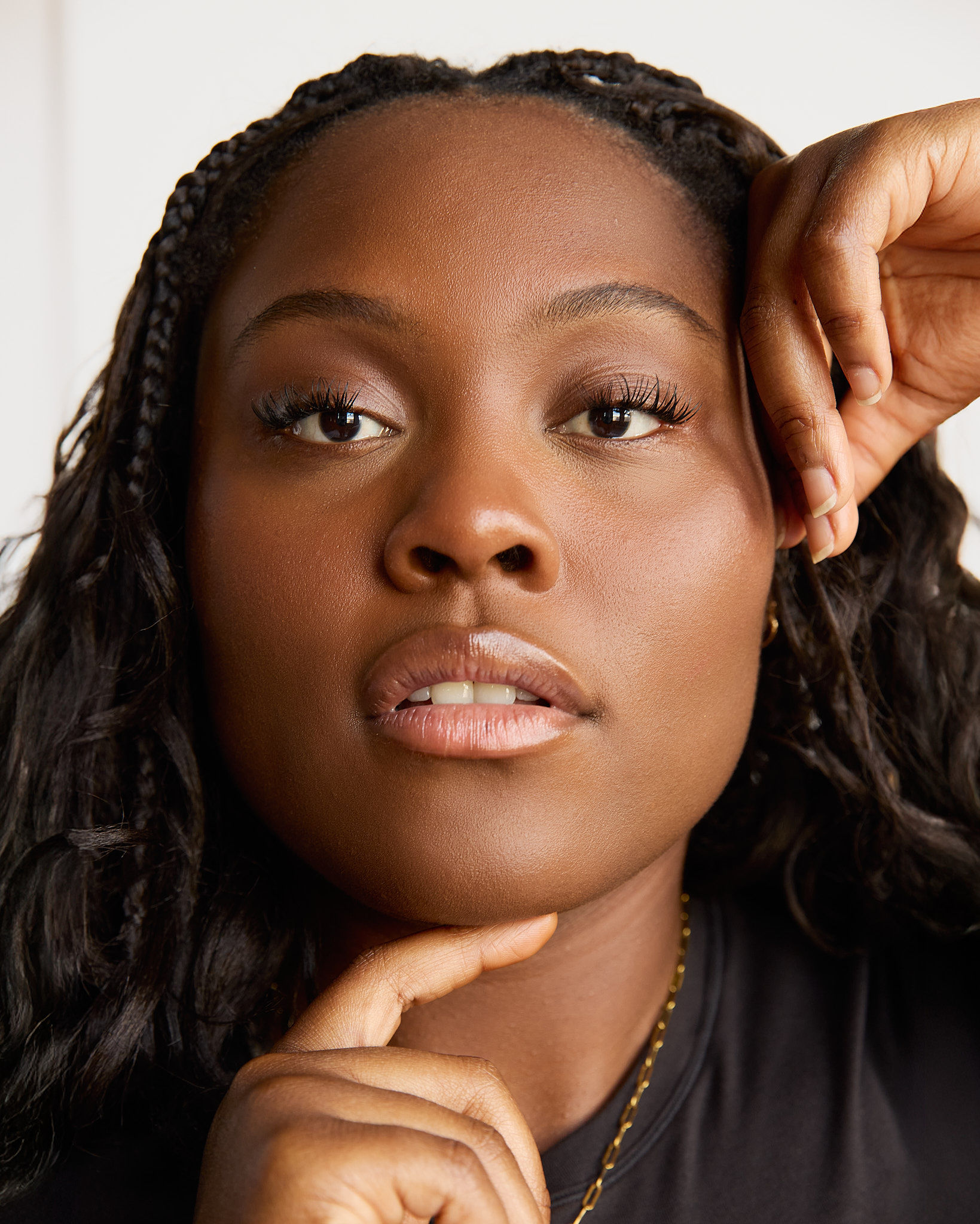 Woman with large sunglasses and jewelry touching her face