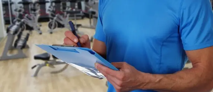 Certified gym repair technician fixing commercial elliptical equipment for Calgary fitness center