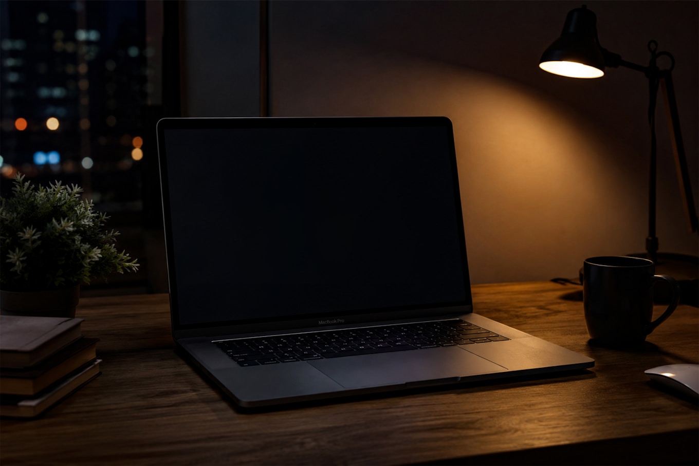 A laptop glowing on a wooden desk late at night