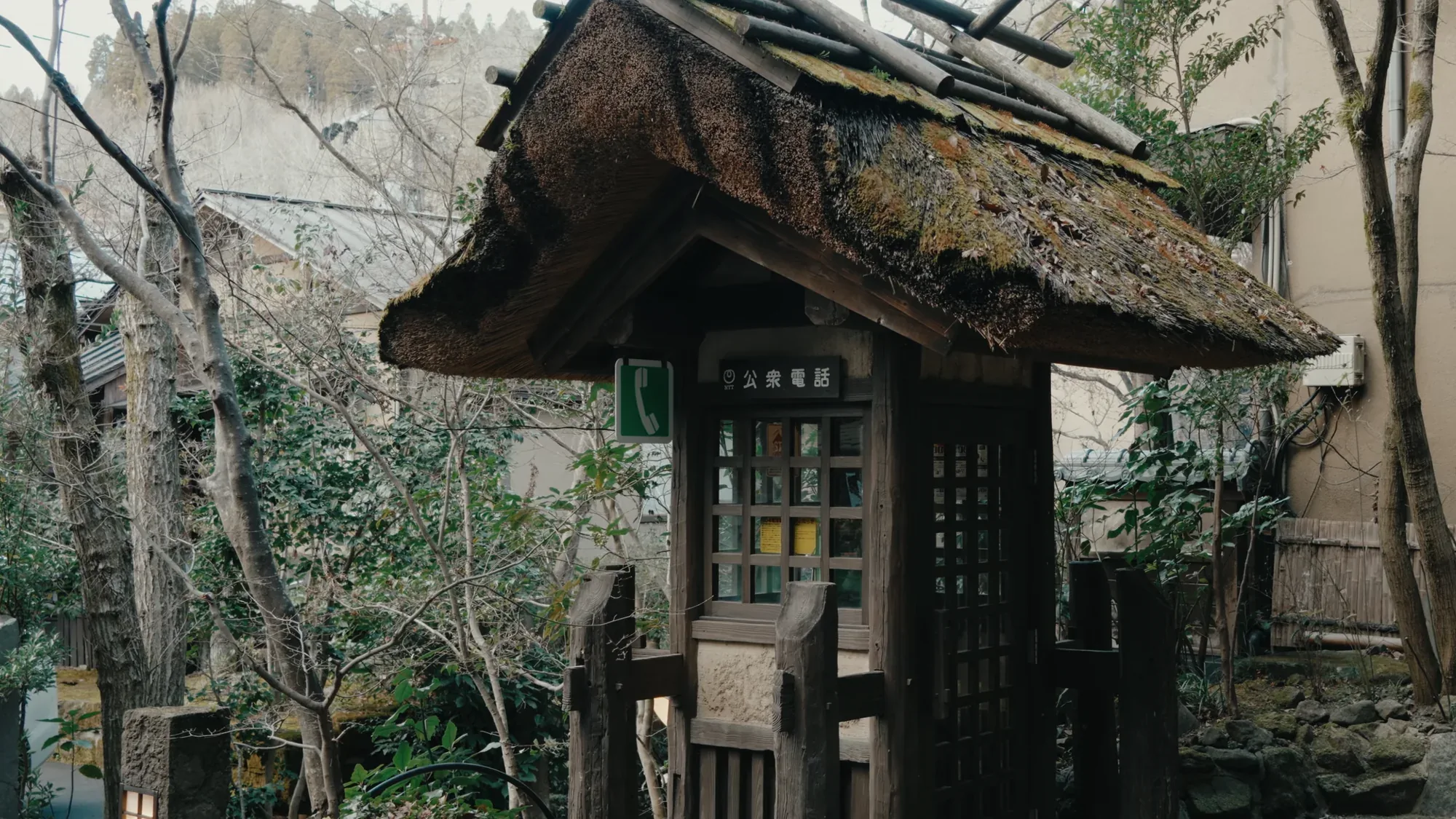 A roofed timber noticeboard at Kurokawa Onsen carrying a posted notice