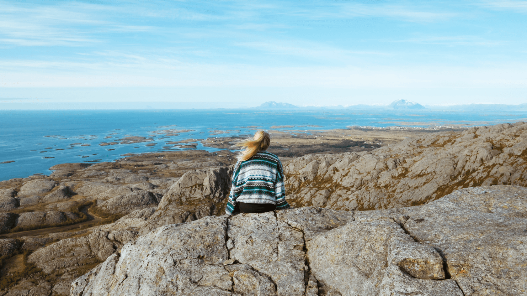 A woman sitting on rocks enjoying the view
