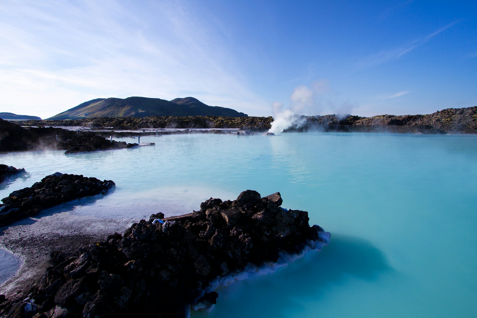 Blue Lagoon geothermal spa surrounded by black lava fields with steaming mineral-rich water in Iceland.
