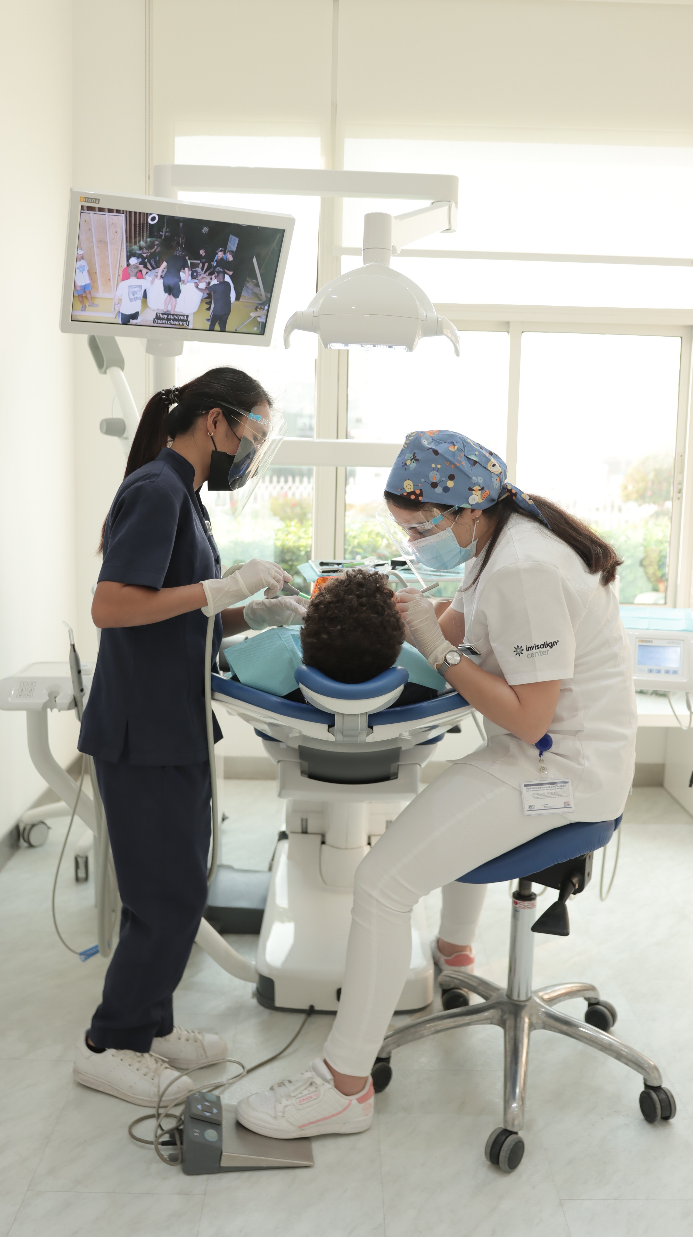 A patient sits in a dental chair while a dental assistant prepares for a consultation and tooth preparation in Dubai.