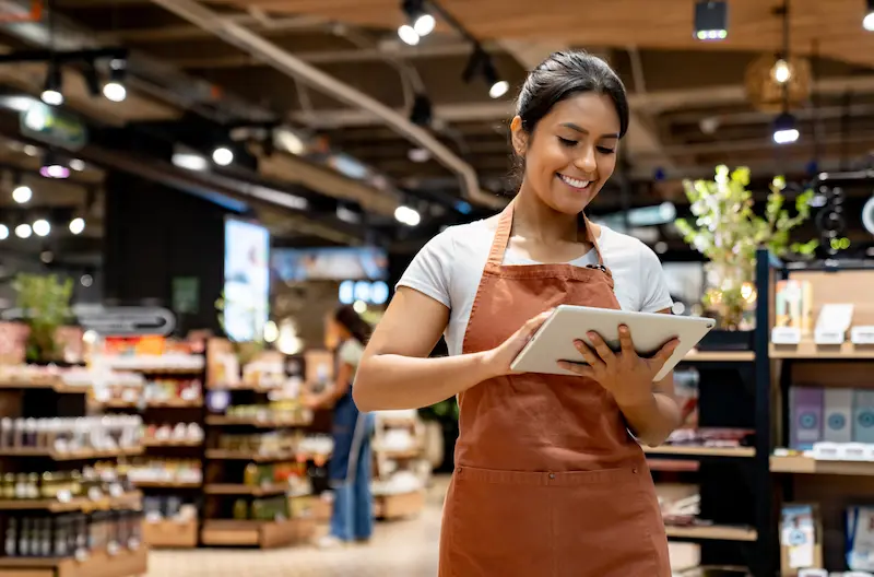 Woman smiling while is checking her ipad and the maintenance TickedOff app