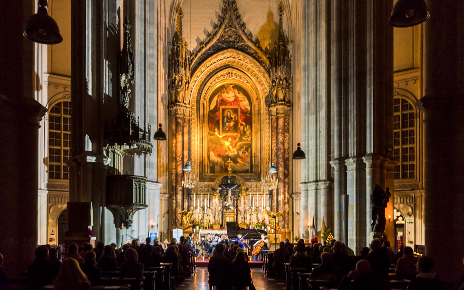 Classical concert at Minoritenkirche with audience seated in the illuminated church interior.