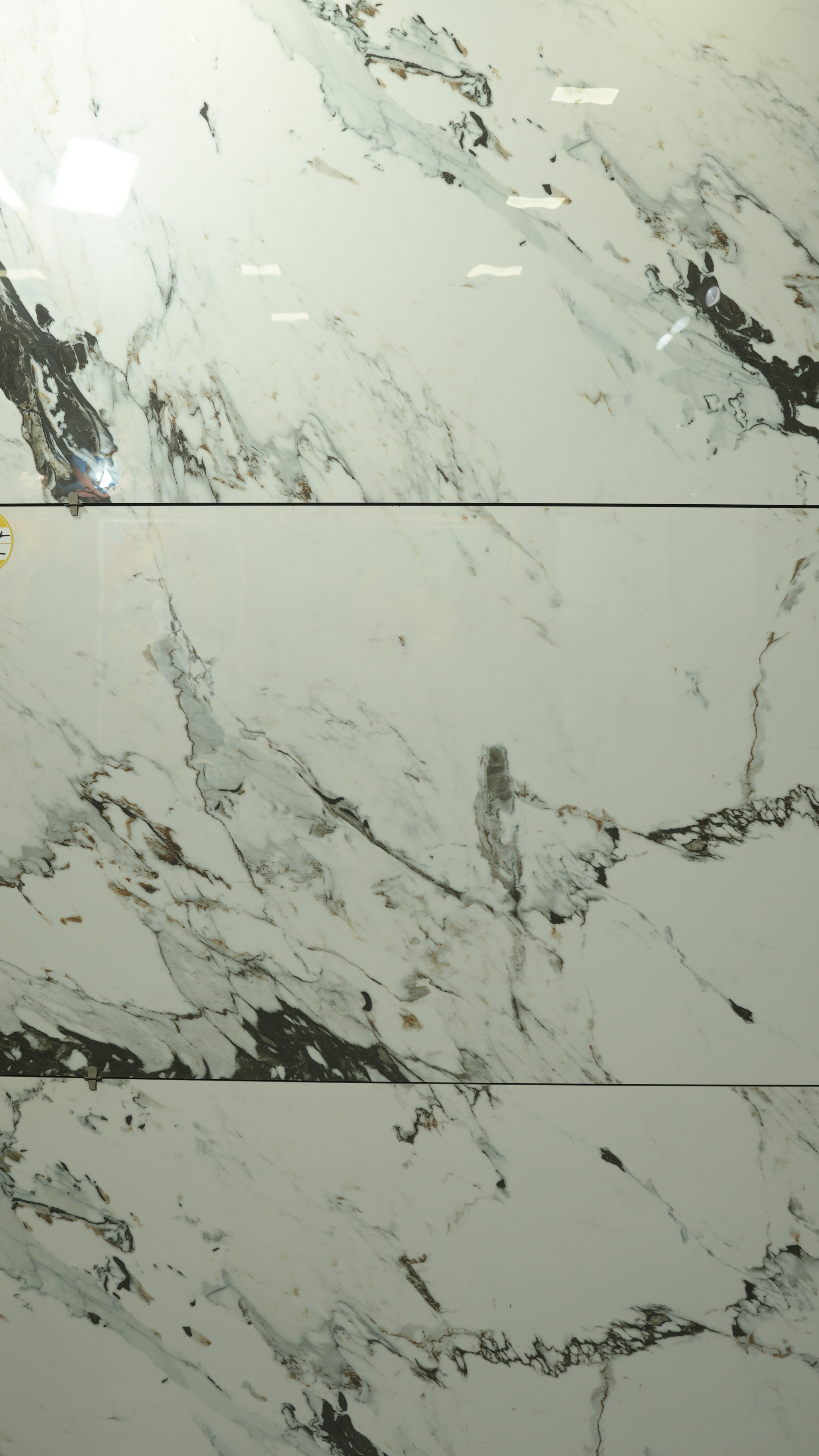 Modern living room with abstract art, beige sectional sofa, indoor plants, and large windows.