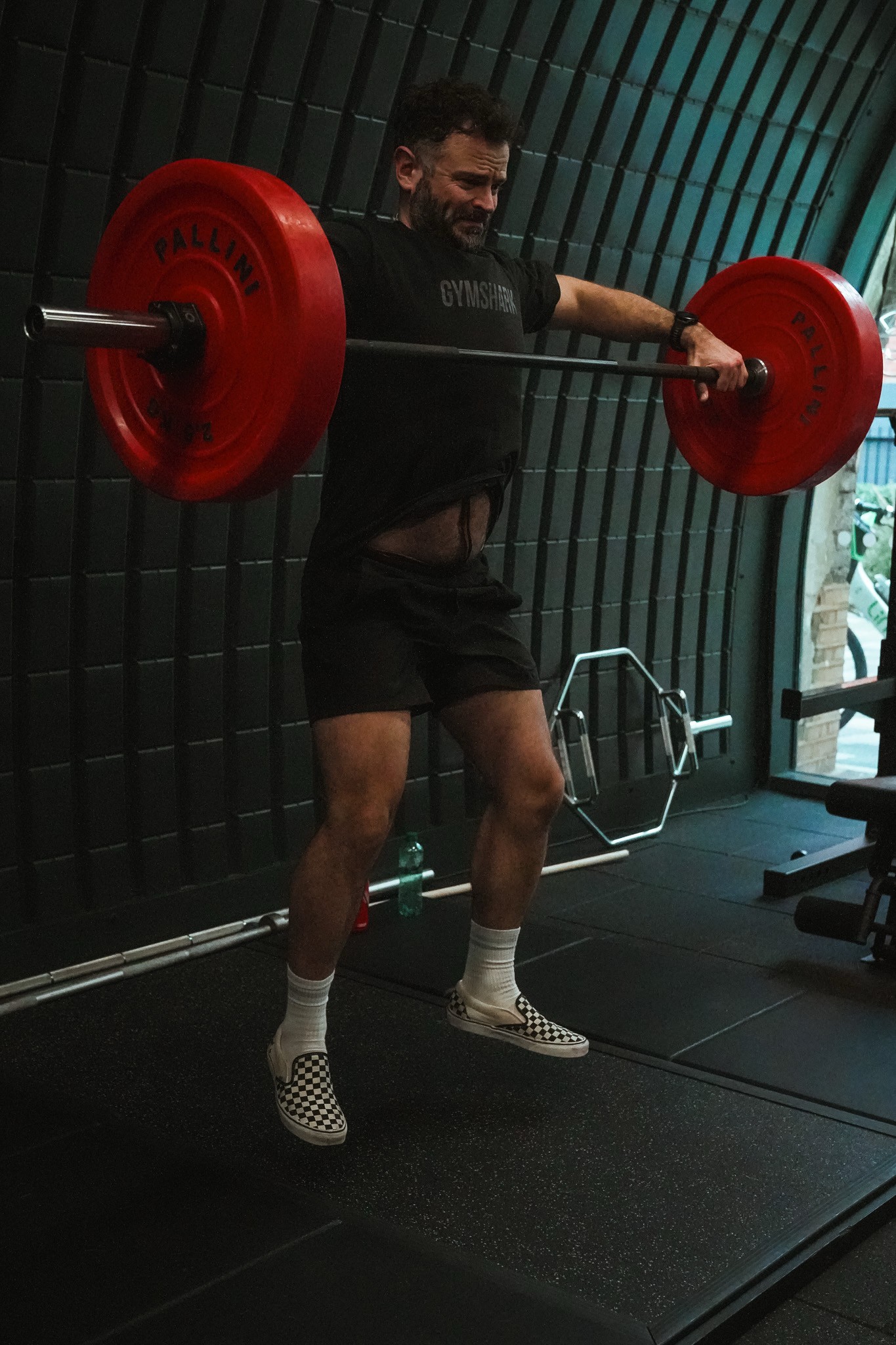 a man squatting with a barbell in his hands
