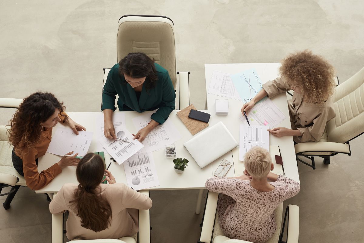 People working at a table with papers and cups.