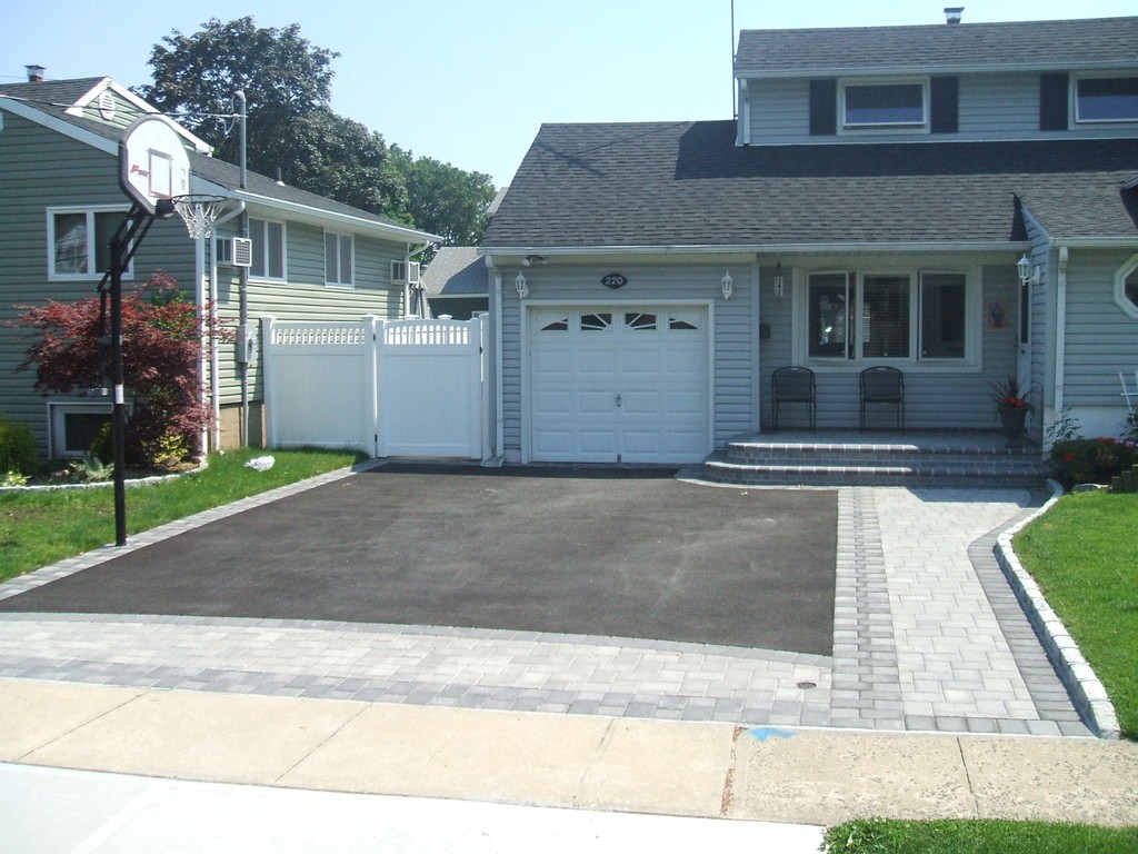 Asphalt driveway with stone paver border and modern curb design
