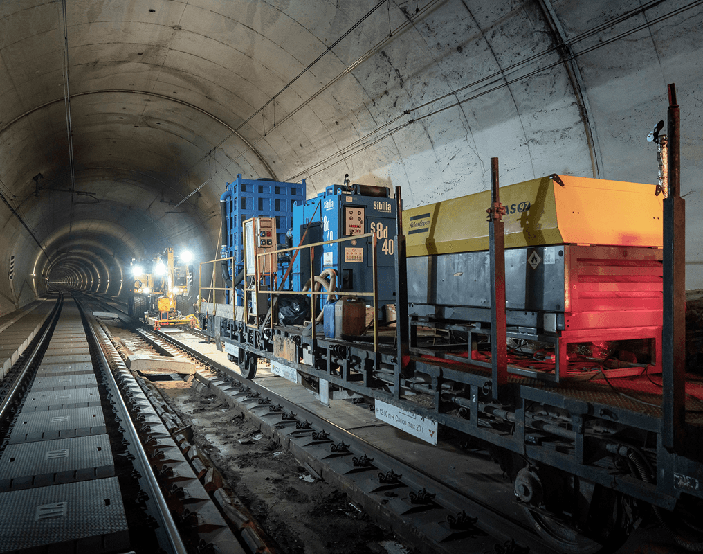 Macchinari ferroviari specializzati Sibilia su carrelli all'interno di galleria durante lavori di manutenzione binari