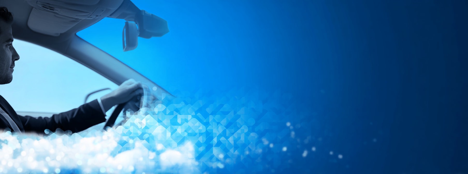 eine person fährt auto, neben ihm sieht man den blauen himmel und wolken