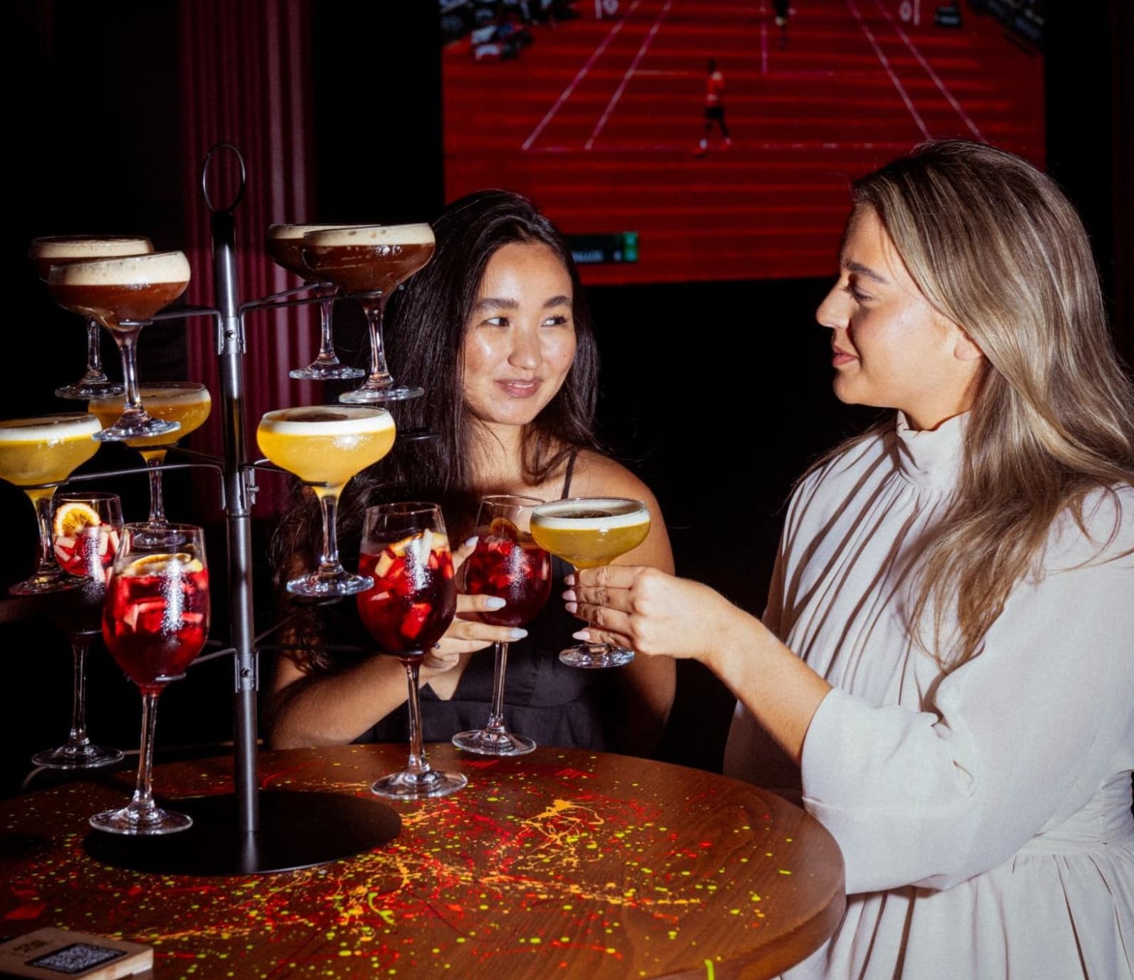 Happy hour Dubai with two female friends enjoying their cocktail drinks.