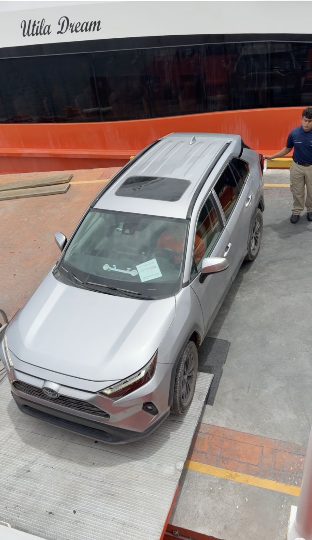A silver Toyota RAV4 driving up the loading ramp onto the car ferry to Roatán.