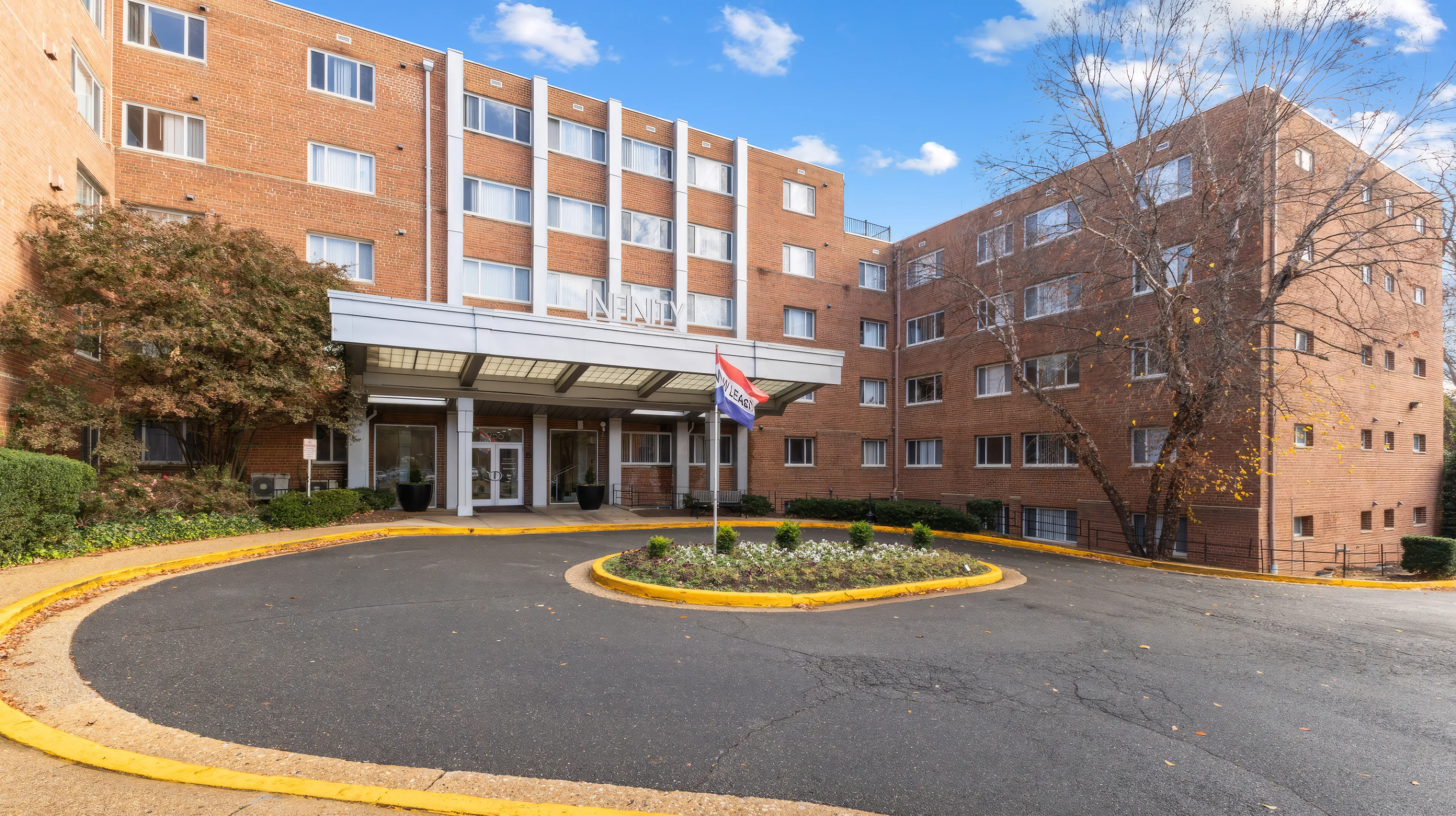 Entrance to an apartment building located at the corner of a street, featuring a welcoming doorway and surrounding sidewalk.