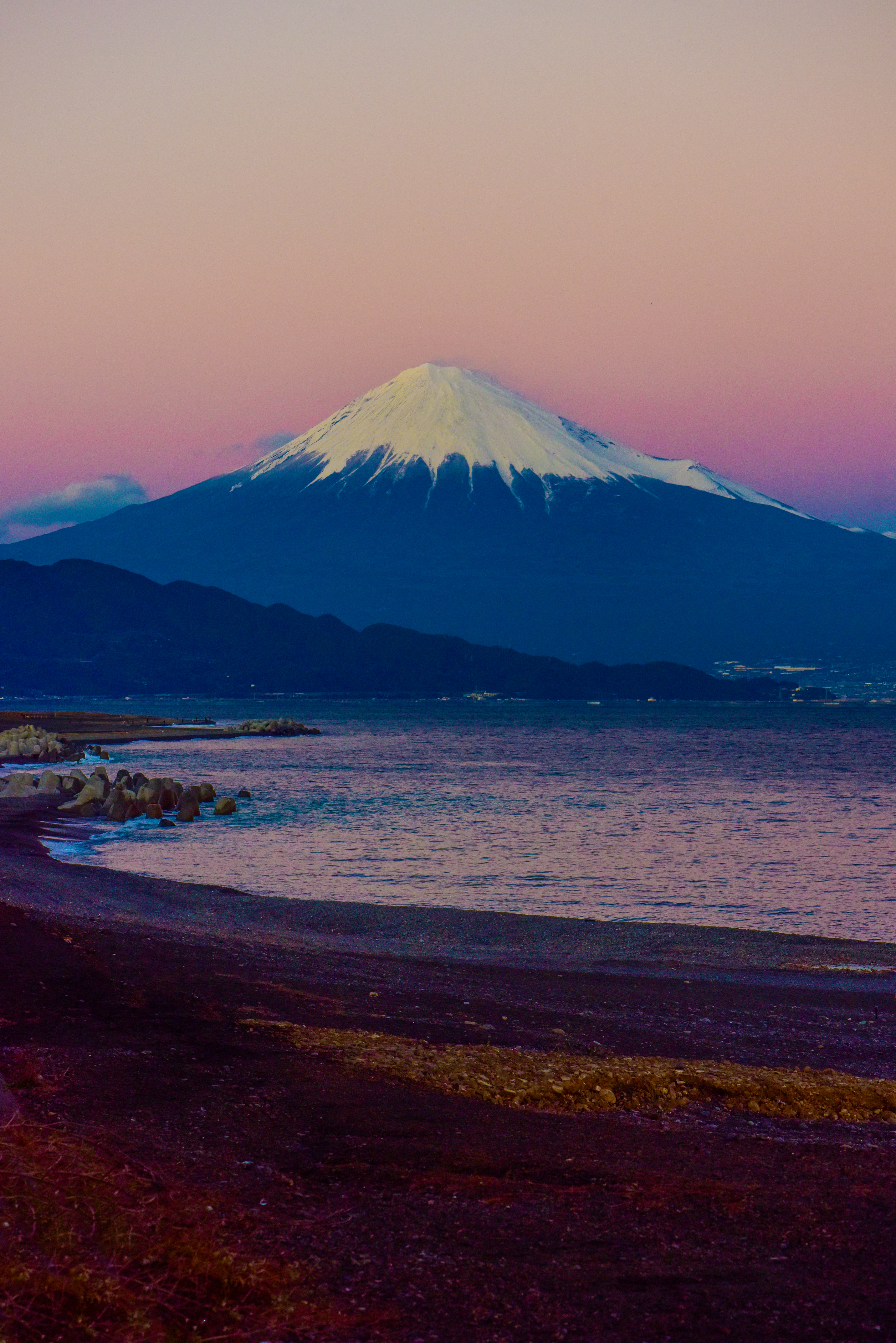 brown sand beach near mountain under white clouds during daytime