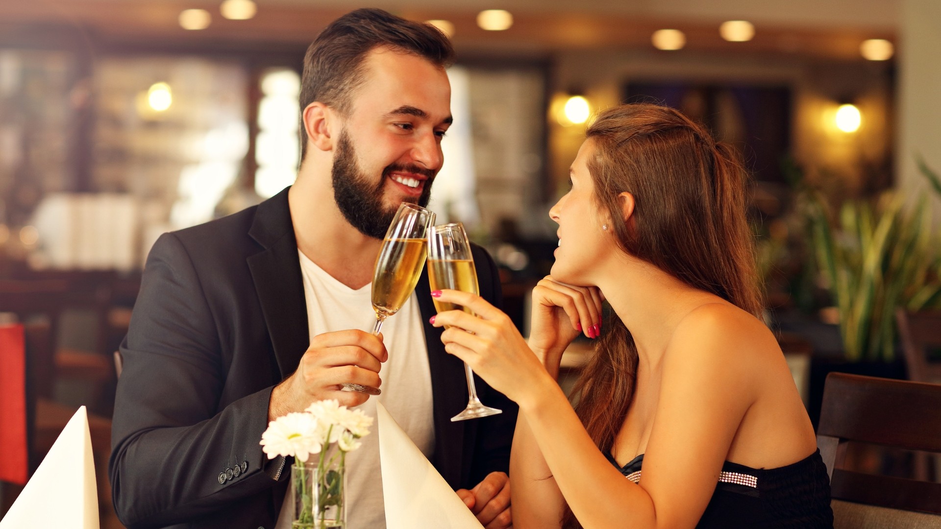 ein mann und eine frau stoßen an, sie trinken sekt