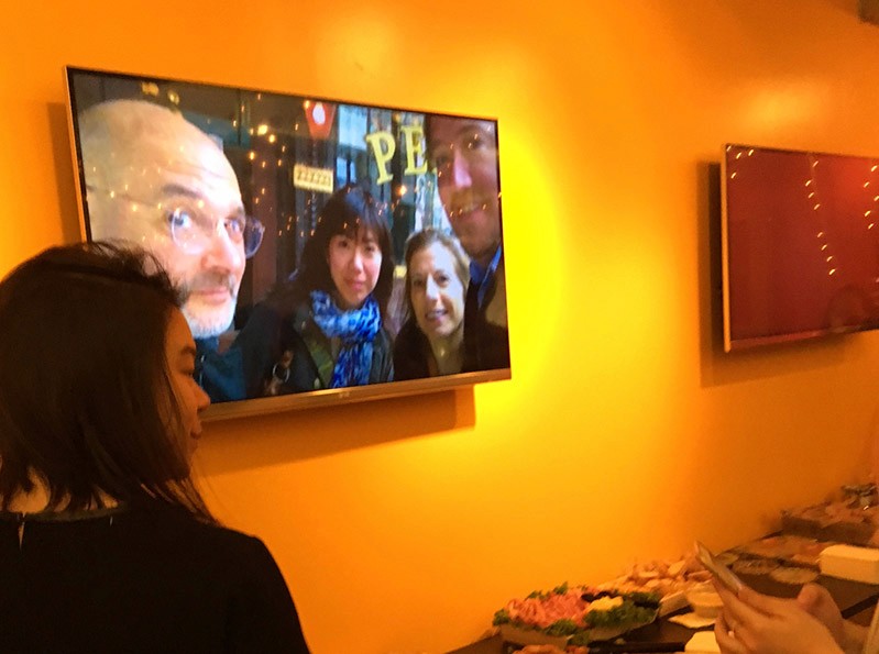 a tv screen displaying a group photo of two men and two women