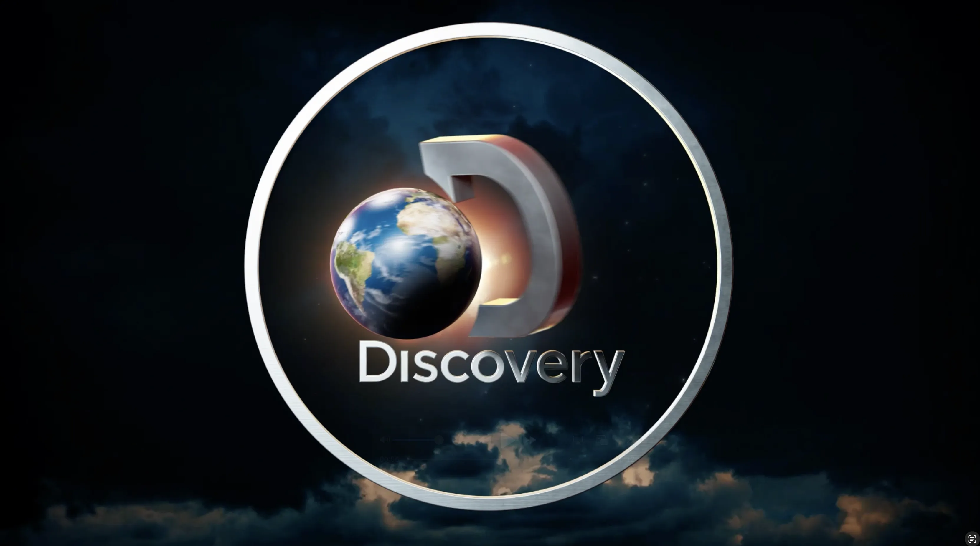 Chrome three dimensional letter D encircling a realistic Earth with clouds and sky in the background. Discovery wordmark below.