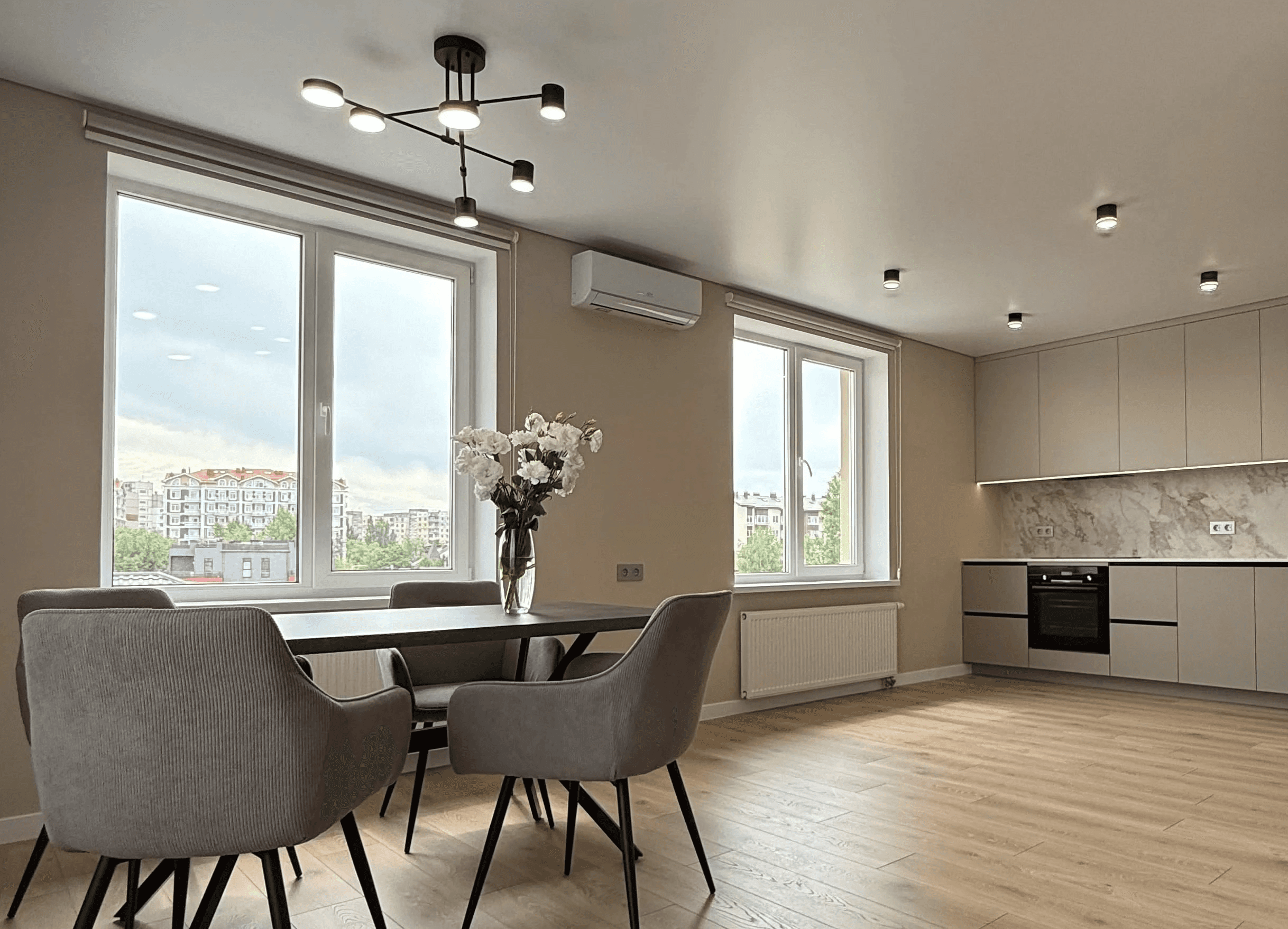 Кухня з обідньою зоною біля вікна та світлими фасадами