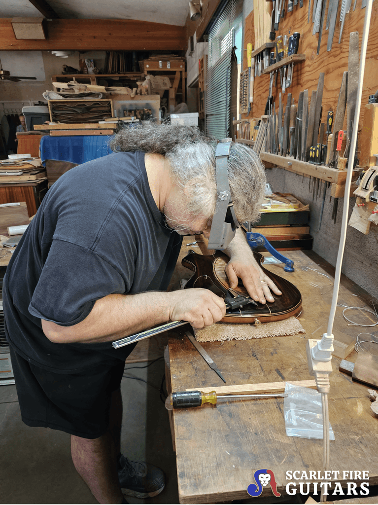 Leo Elliot with Jerry Garcia's Tiger guitar on the workbench, measuring, Doug Irwin's shop