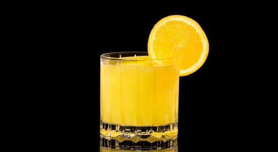 A closeup of a Screwdriver drink against a dark background.