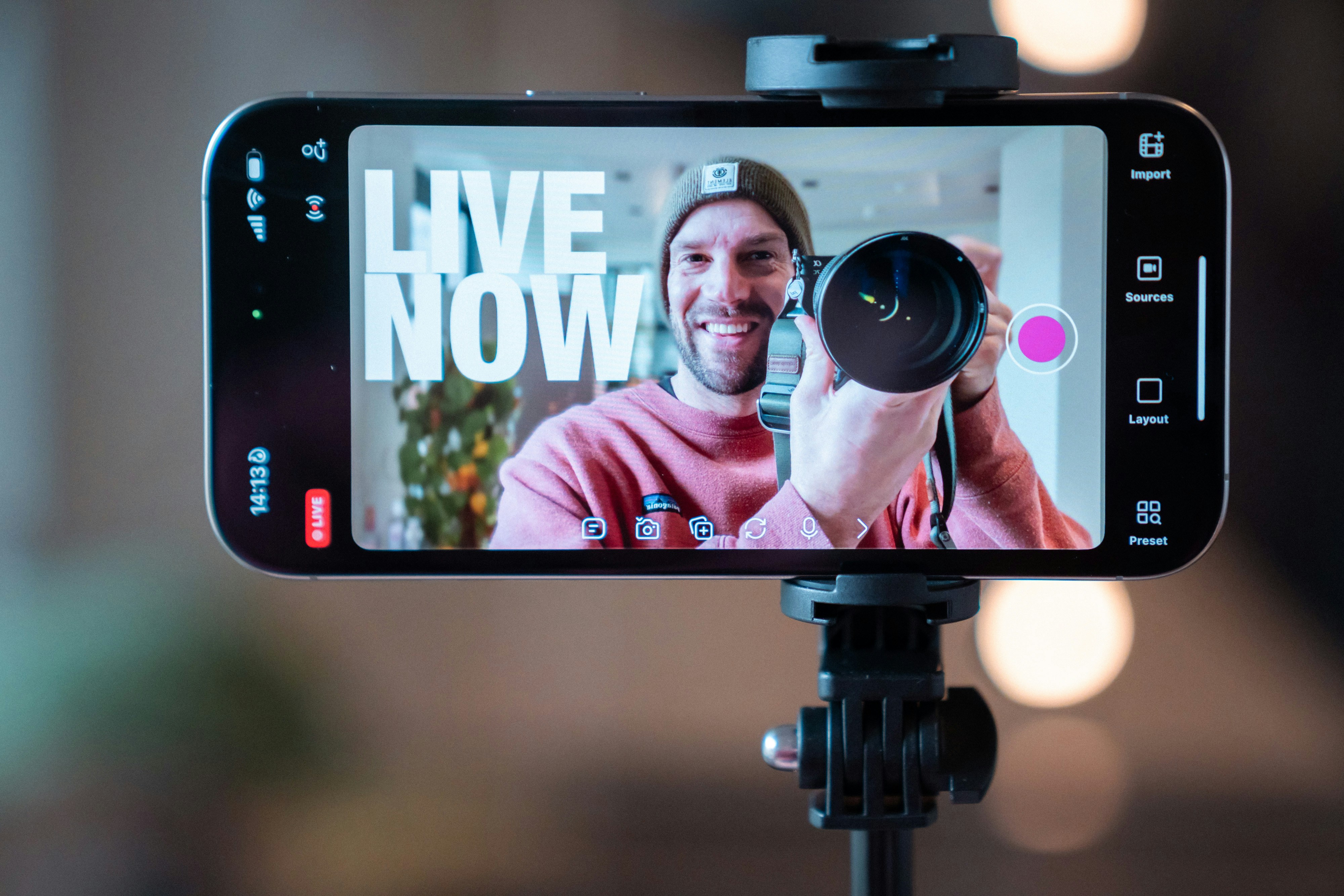 Man filming with camera on phone screen live now