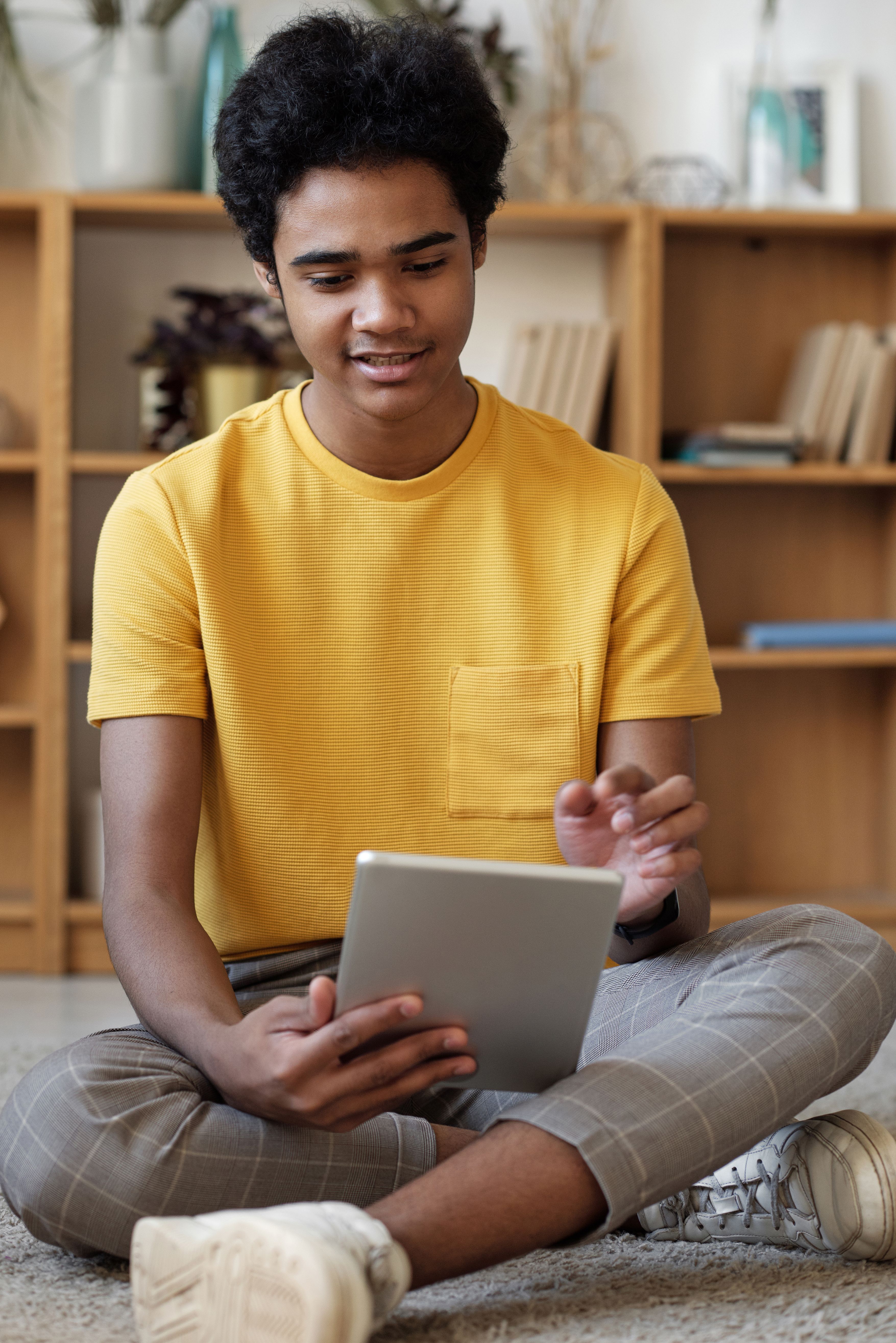 A student is working on a tablet, focused on the screen