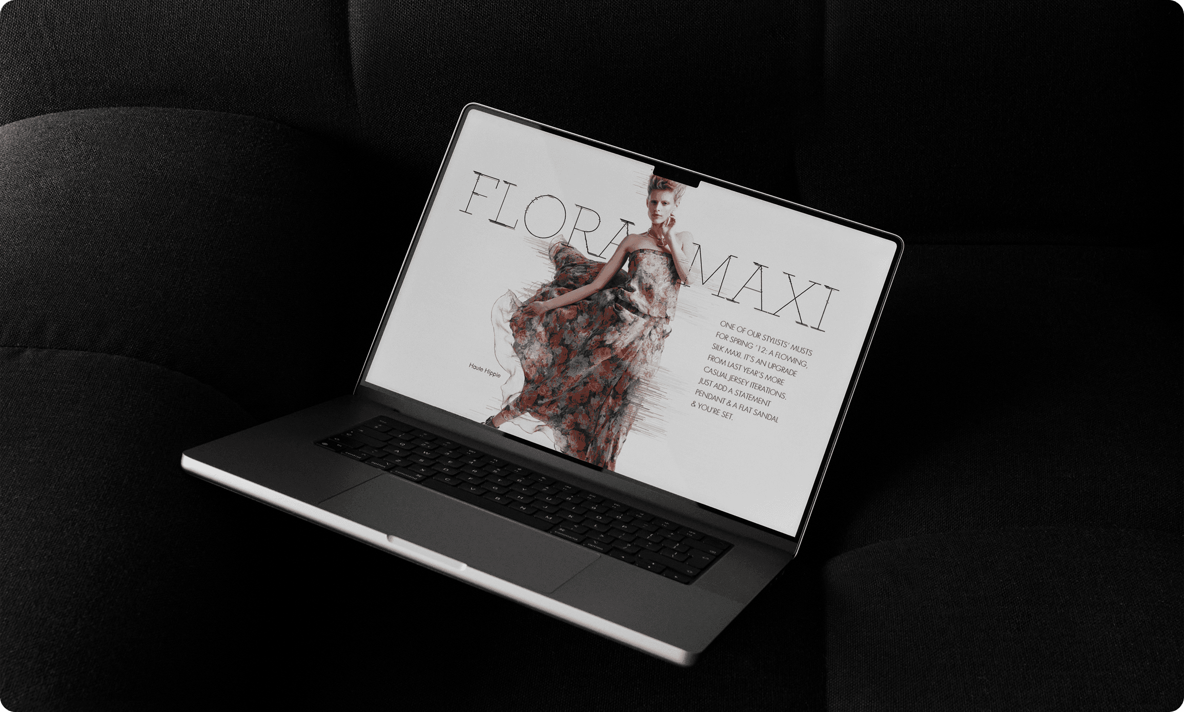 Laptop displaying Floriani fashion editorial design with model in flowing floral dress on dark fabric background