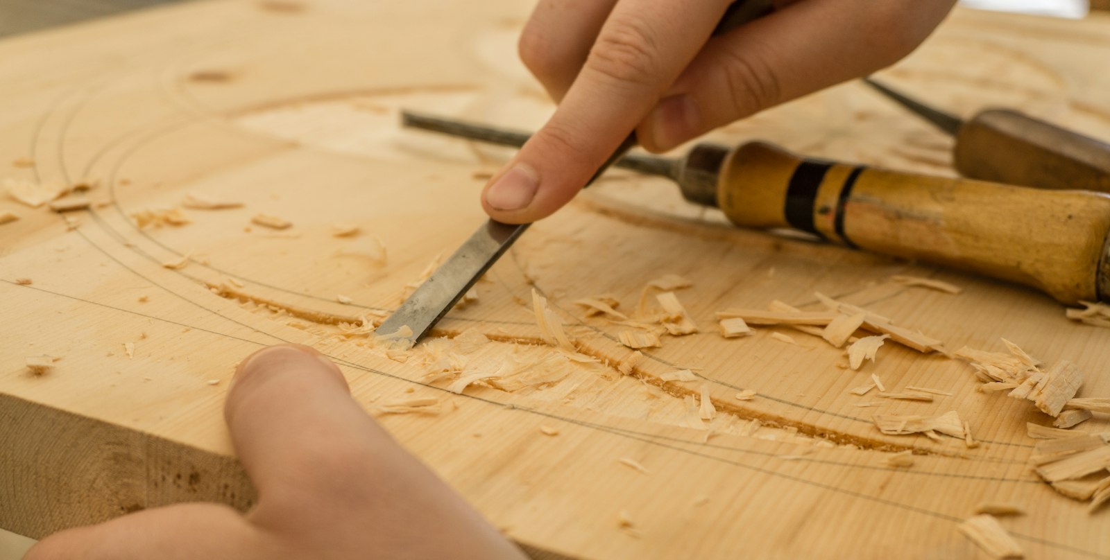 A chisel shaping a piece of wood