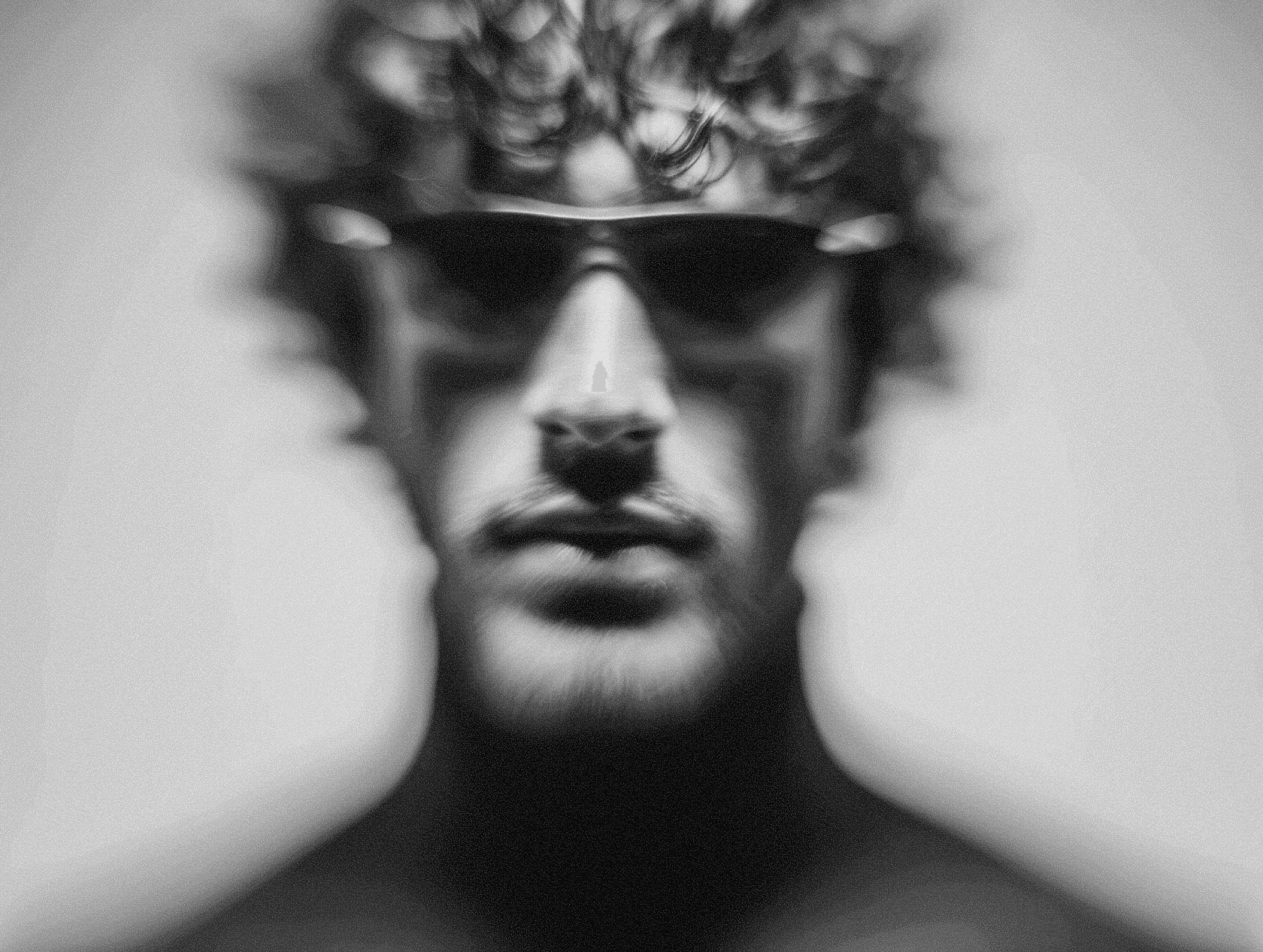 A male figure wearing sunglasses and a jeweled crown with a regal expression