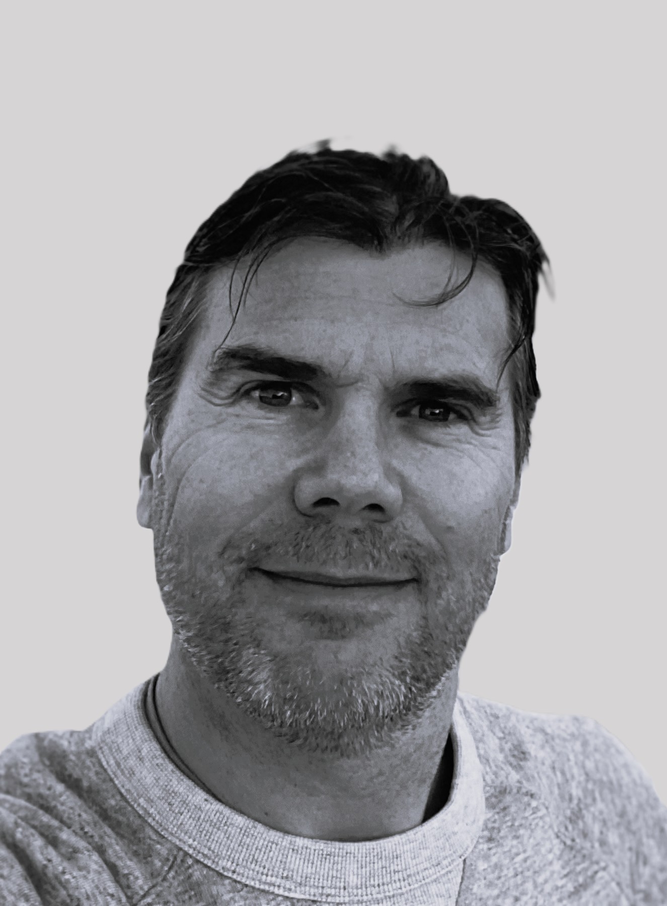 Portrait of a man with blue eyes and a beard, wearing a denim shirt