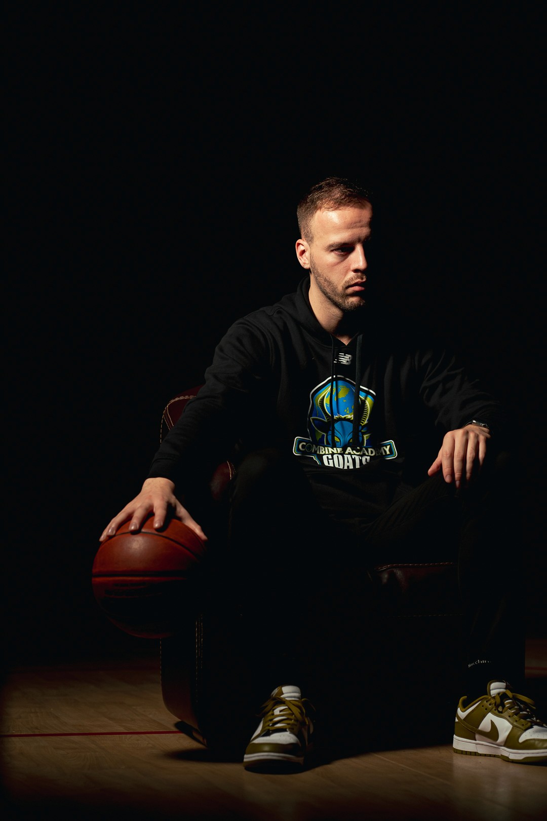 Portrait sportif d’un homme en sweat Combine Academy, éclairé par une lumière ciblée.