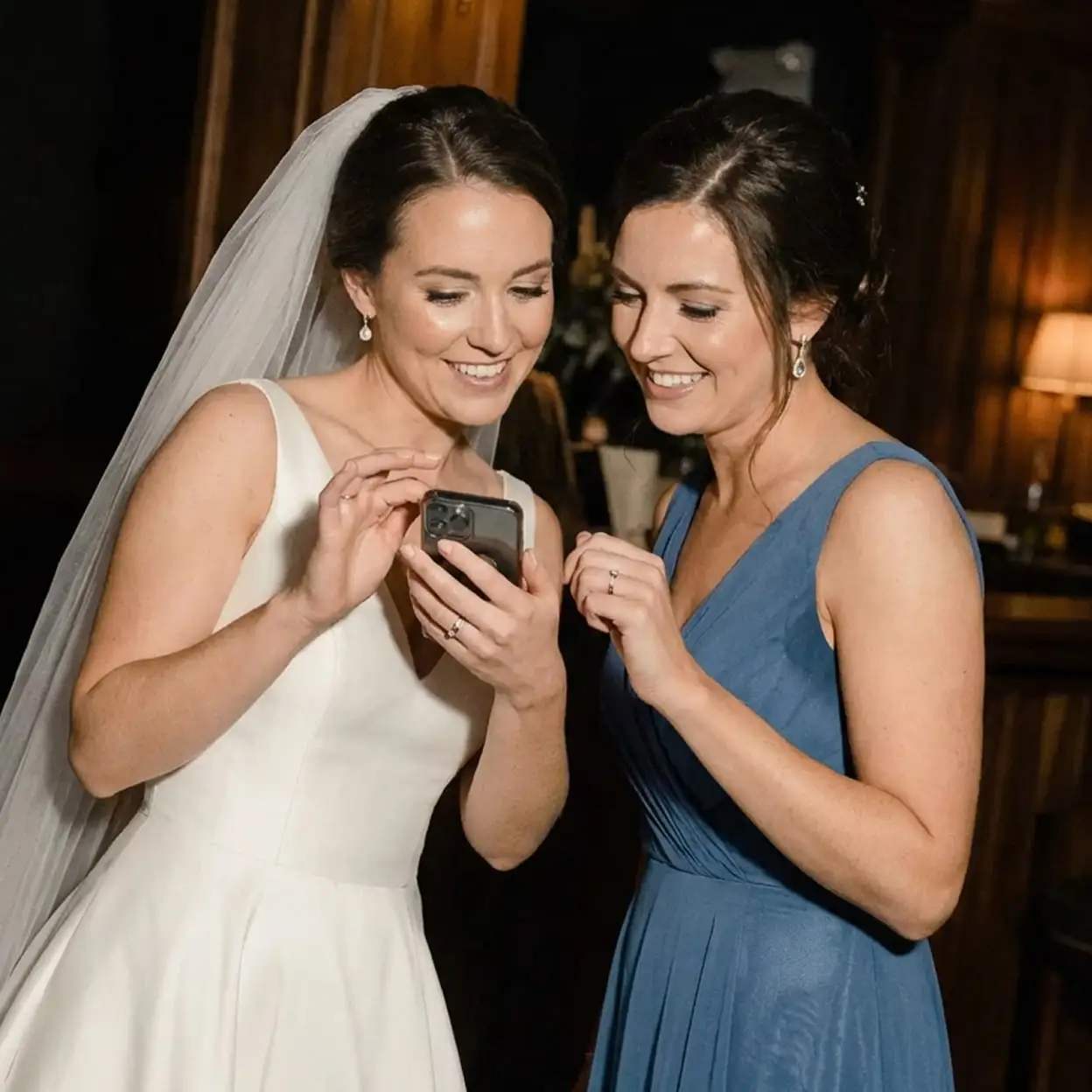 Due persone al matrimonio guardano lo smartphone con l’app di togevent, condividendo informazioni e momenti dell’evento in modo semplice.