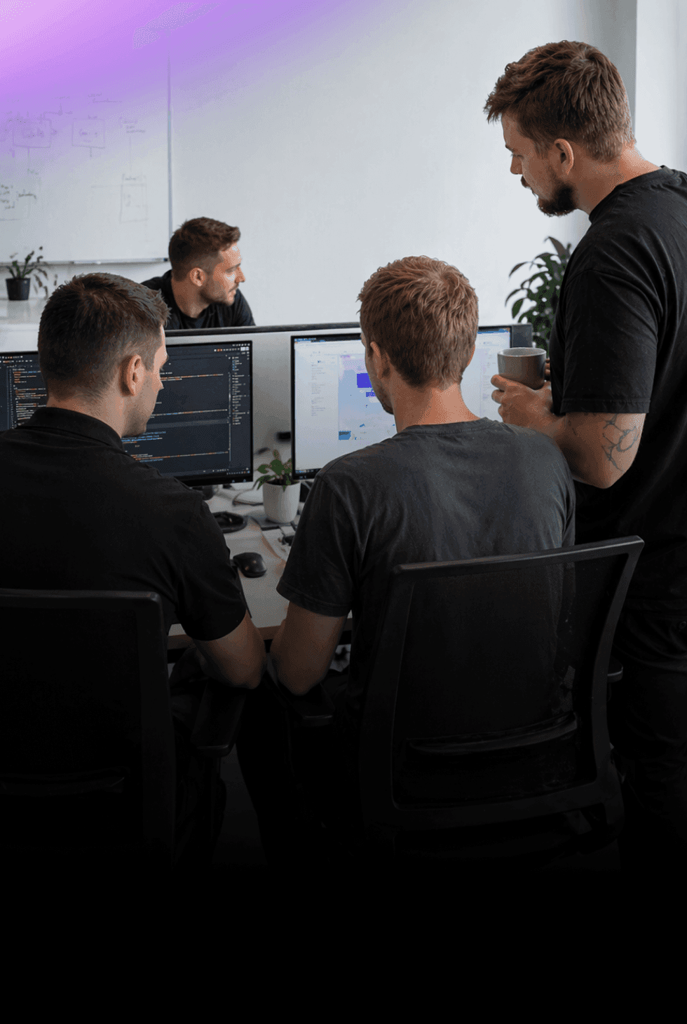 Nextio developers collaborating on custom software development and coding a web application on dual monitors.