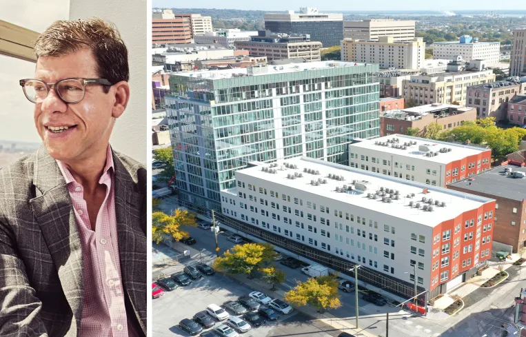 Tall modern skyscraper with vertical lines, viewed against a clear blue sky.