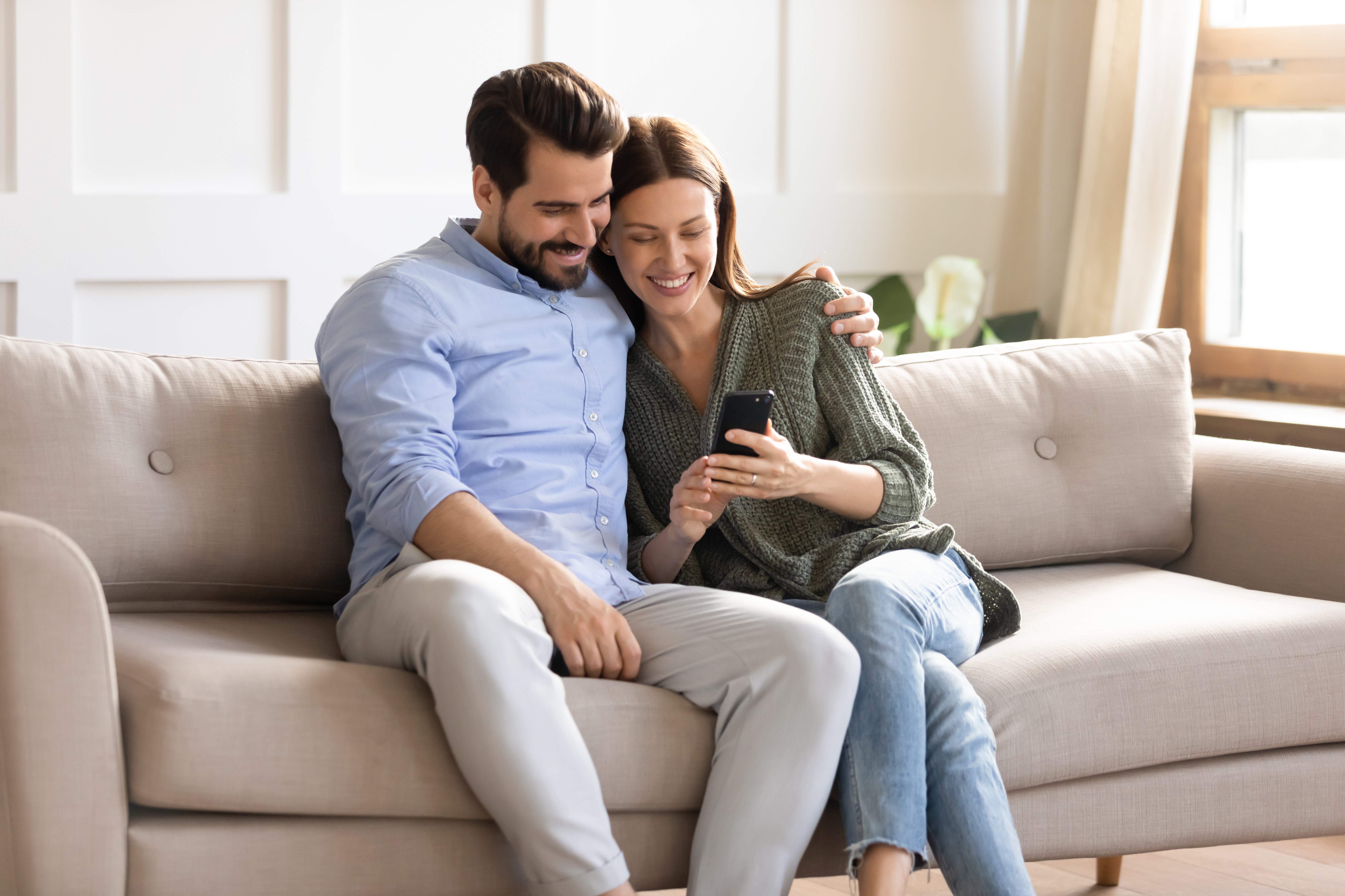 homebuyers looking at novihome on phone on couch