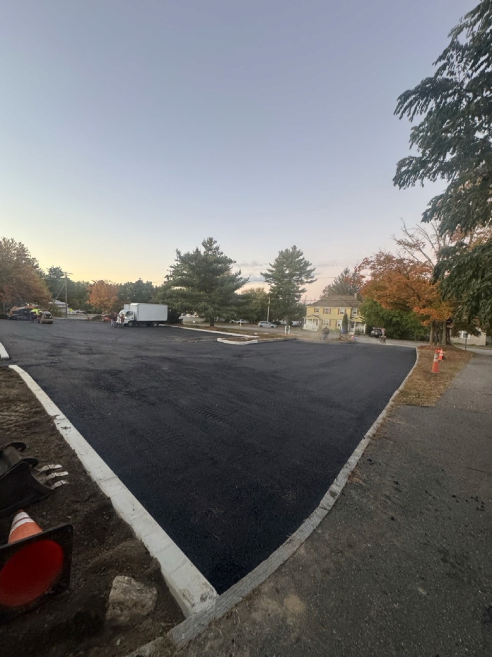 Fresh commercial lot with new curb at dusk, by A&M Construction Enterprises