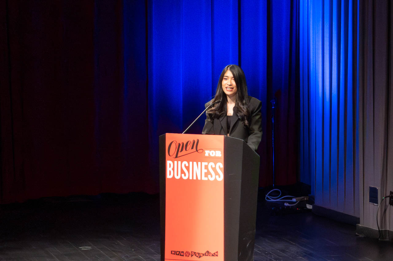 woman standing at a podium delivering a presentation