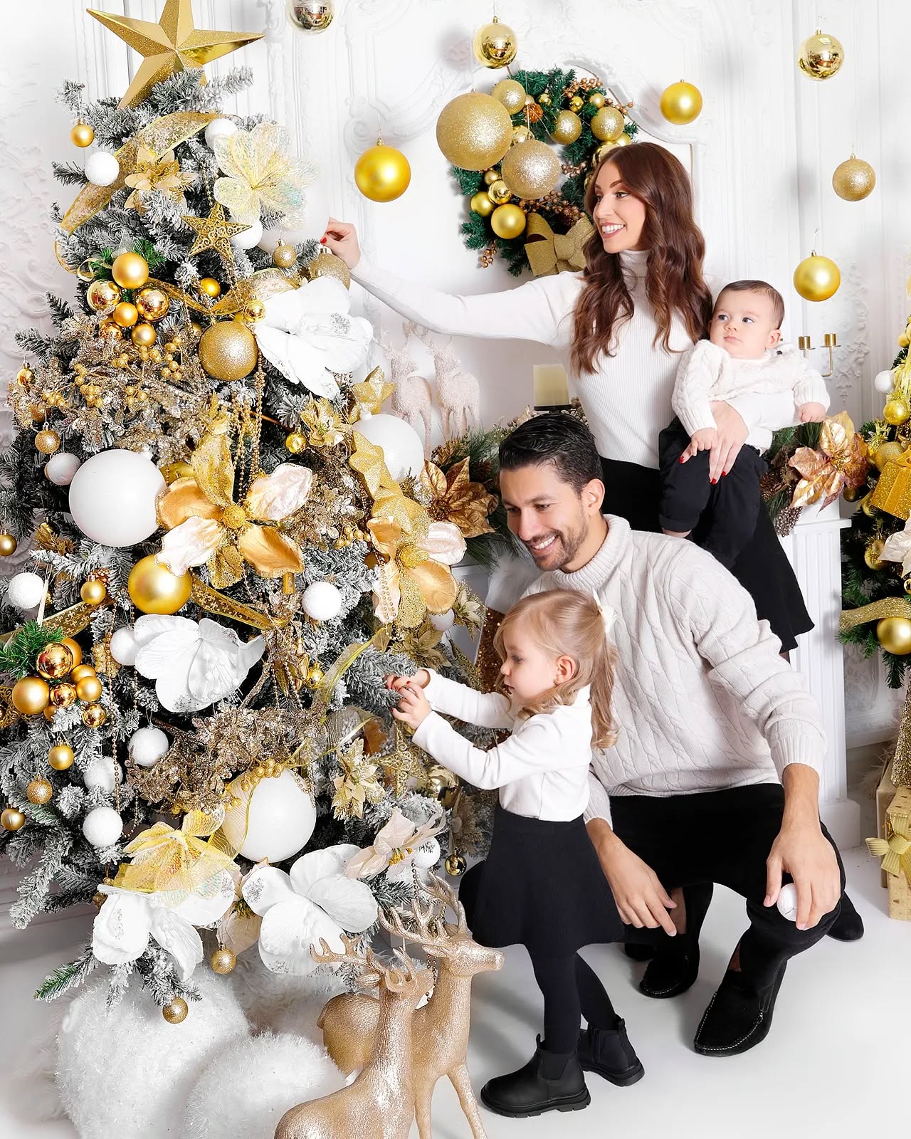 A happy family decorating a Christmas tree, featured in professional Christmas photos in Dubai at Mahvin Photography studio.