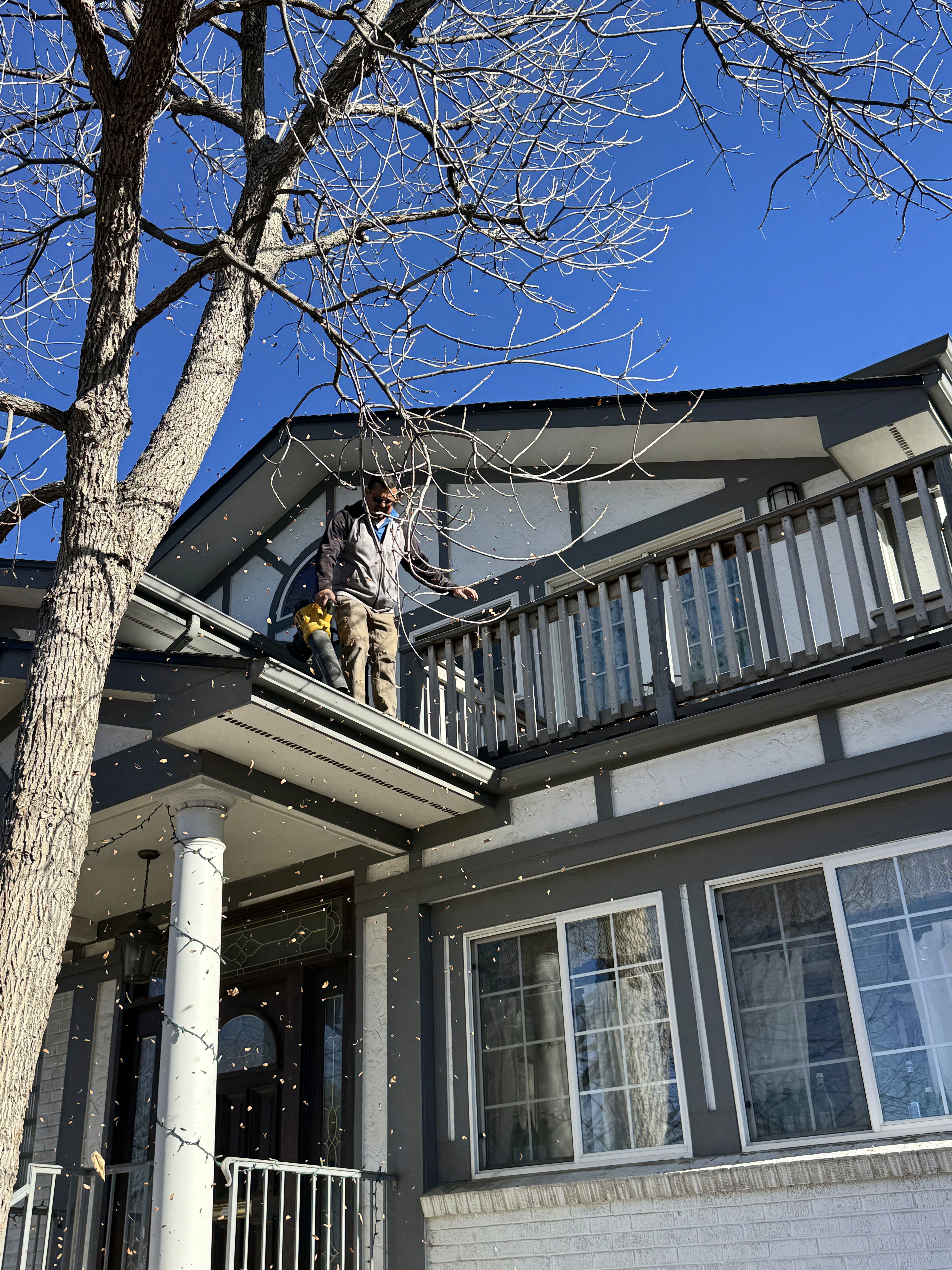 a man working on a roof with a power drill