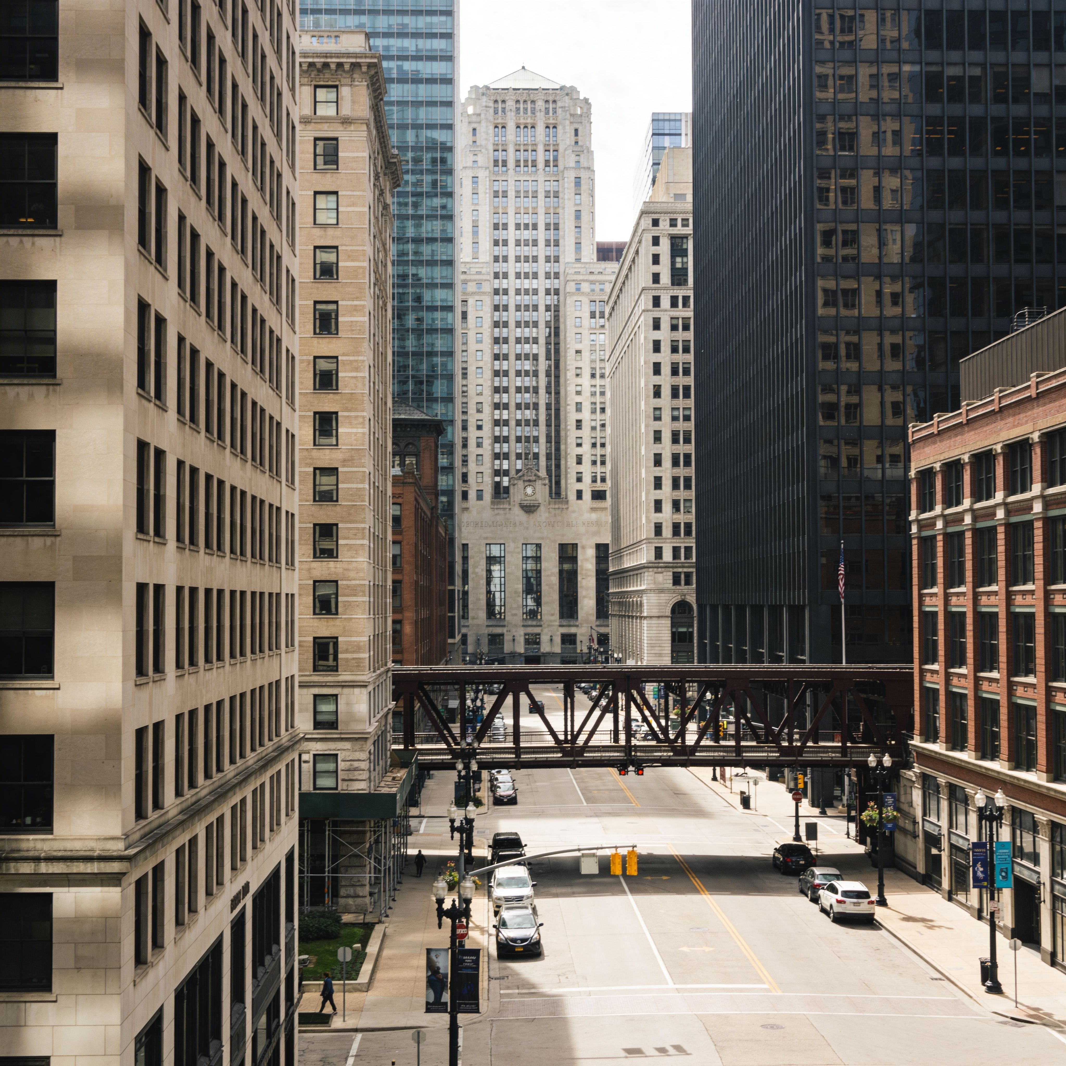 Urban downtown street with historic and modern buildings connected by elevated bridge in Chicago