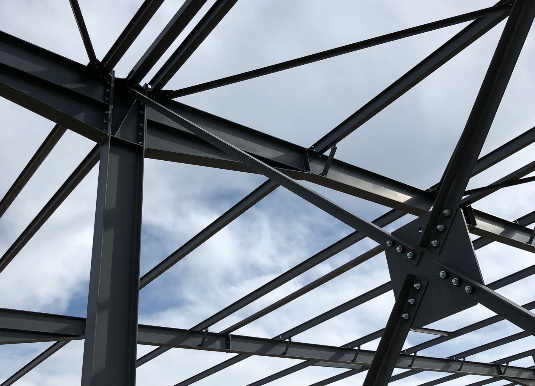 Structure acier en croix de Saint-André, assemblée sur chantier sous ciel nuageux.