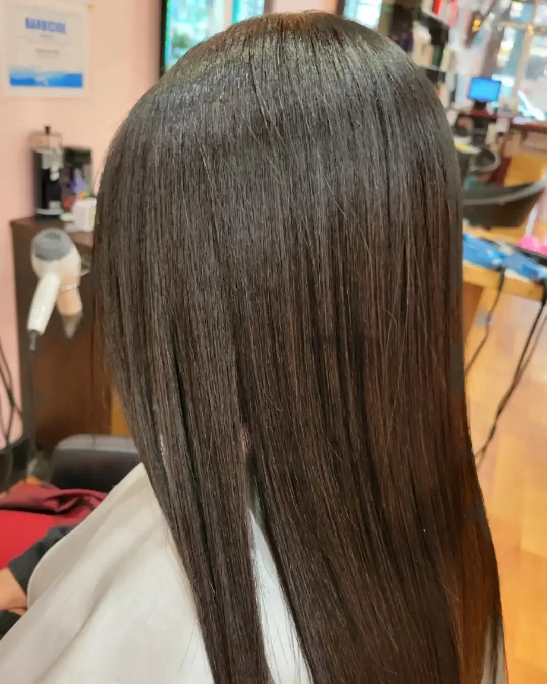 Smooth, glossy straight brown hair after a Brazilian keratin treatment at Hair Pro Charming